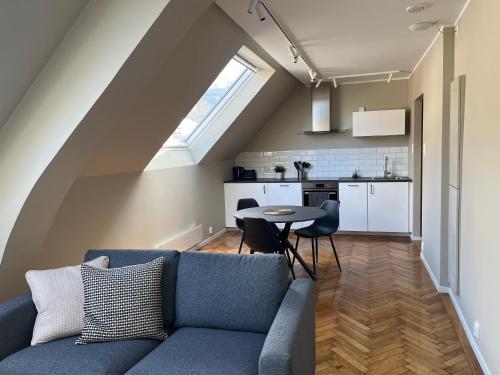 a living room with a blue couch and a table at Kong Oscars Apartments in Bergen