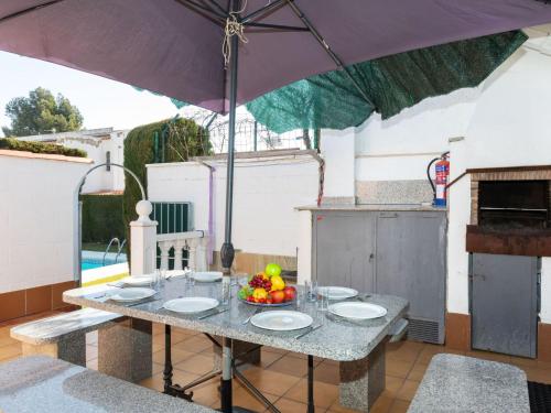 a table with a bowl of fruit and an umbrella at Holiday Home Eden Park 2 by Interhome in Miami Platja