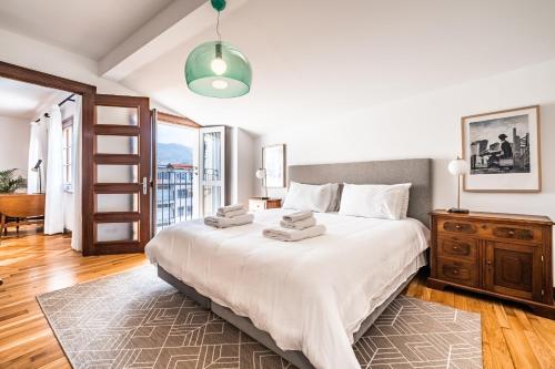 a bedroom with a large white bed and a window at Apartament 6 - By WeHost in Funchal
