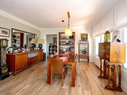 una sala da pranzo con tavolo in legno e una stanza con oggetti vari di Apartment Millenium by Interhome a Premia de Dalt