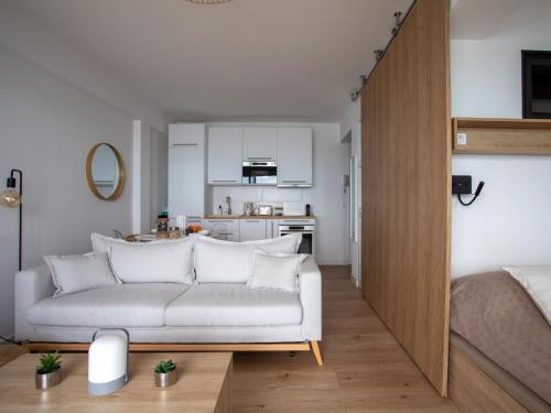 Apartment L'Angelina-2 by Interhome في كاجنيس سور مير: غرفة معيشة مع أريكة بيضاء ومطبخ