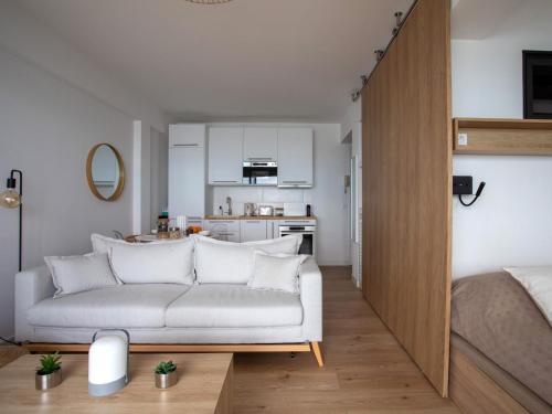 un salon avec un canapé blanc et une cuisine dans l'établissement Apartment L'Angelina-2 by Interhome, à Cagnes-sur-Mer