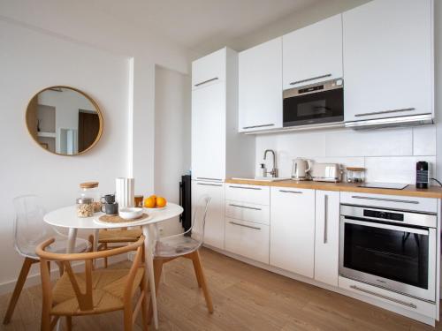 - une cuisine blanche avec une petite table et un miroir dans l'établissement Apartment L'Angelina-2 by Interhome, à Cagnes-sur-Mer