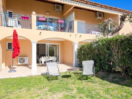 ein Haus mit 2 Stühlen und einer Terrasse in der Unterkunft Apartment Le Domaine de Figuière-2 by Interhome in Sainte-Maxime