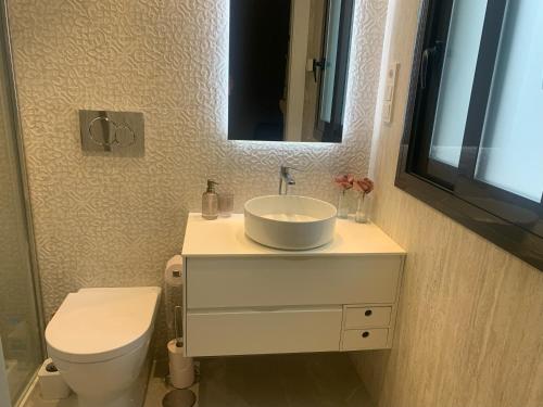 a bathroom with a sink and a toilet and a mirror at Casa Tierra Torrievieja close to the beach Playa del Cura in Torrevieja