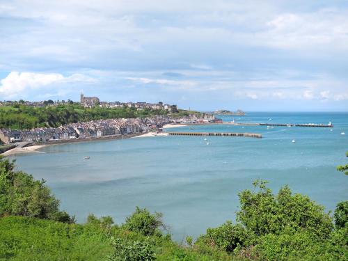 a view of a beach with a pier in the water at Apartment Vue Eméraude by Interhome in Cancale