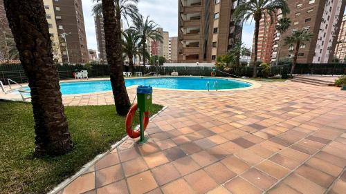 a swimming pool in a city with palm trees at Esperanto 17. in Benidorm