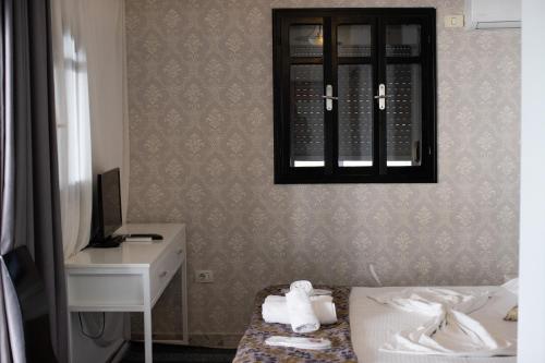 een slaapkamer met een bed, een bureau en een spiegel bij VILA SANREMO in Tirana