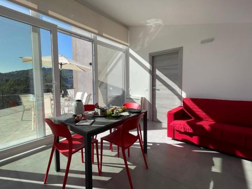 a living room with a table and a red couch at Holiday Home Casa Noemi by Interhome in Imperia