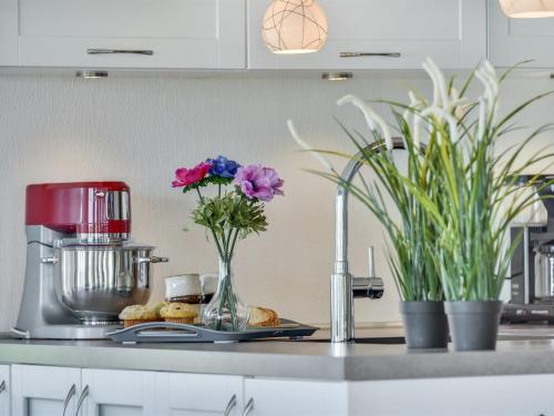 una encimera de cocina con flores en un jarrón y una batidora en Holiday Home Ejna in Western Jutland by Interhome, en Bredebro