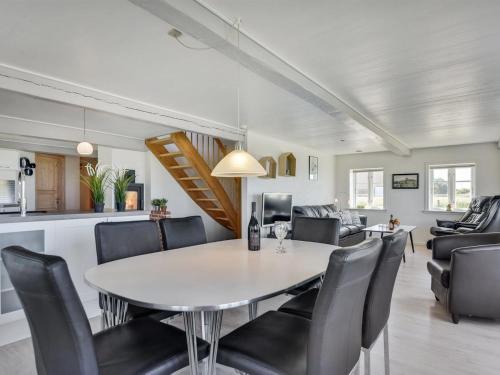 a dining room and living room with a table and chairs at Holiday Home Ejna by Interhome in Bredebro