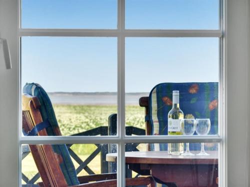a table with a bottle of wine and two glasses at Holiday Home Ejna by Interhome in Bredebro