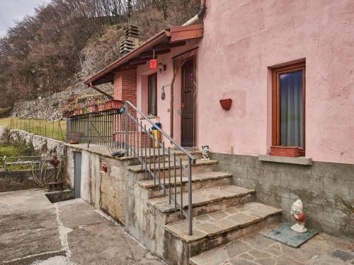 ein rosa Haus mit Treppe davor in der Unterkunft Holiday Home Casa Rosy by Interhome in Porlezza