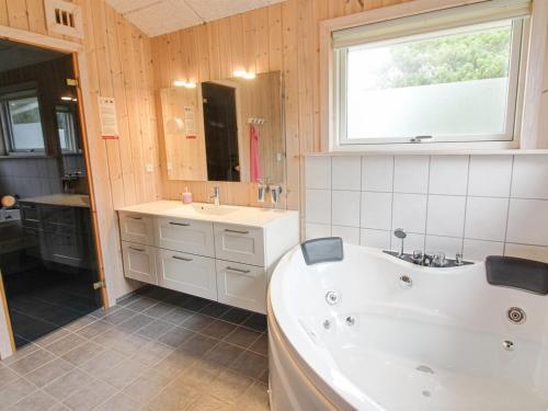 baño con bañera, lavabo y ventana en Holiday Home Griselda - 700m from the sea in NW Jutland by Interhome en Torsted