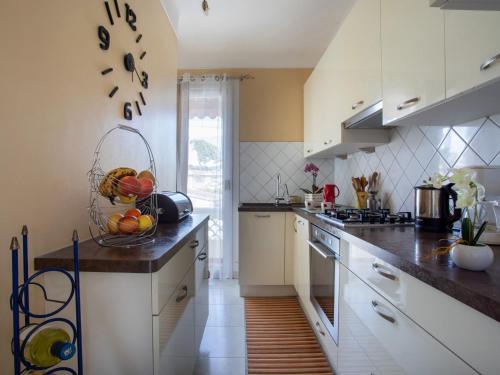 - une cuisine avec des placards blancs et une corbeille de fruits sur le comptoir dans l'établissement Apartment le flora by Interhome, à Villeneuve-Loubet