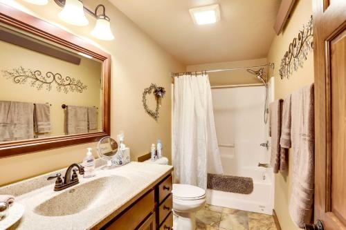 a bathroom with a sink and a toilet and a mirror at Homey Deadwood Apartment in Convenient Spot! in Deadwood