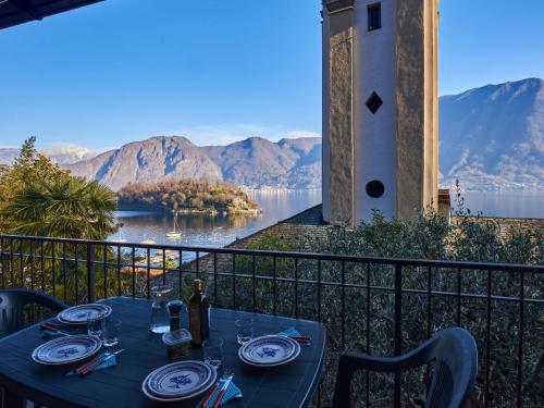 a table on a balcony with a view of a lake at Holiday Home Tower Bell House by Interhome in Isola Comacina