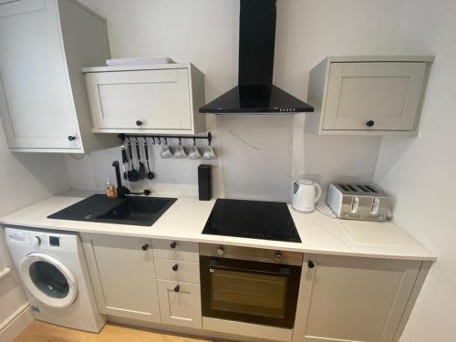 a small kitchen with a stove and a sink at Amazing Two Bedroom Apartment - SR in Southport