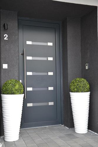 two large white plants in front of a door at Apartmany u Polanských in Bulhary