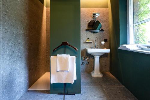 a bathroom with a sink and a towel dispenser at Goldenstern Townhouse in Bolzano