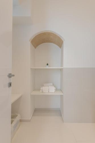 a room with white walls and white shelves at Vittorio Veneto Matera Luxury Rooms in Matera