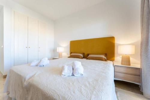 a bedroom with a large white bed with two pillows at CT 199 - Duquesa Village in Manilva