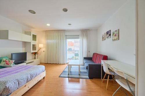 バダロナにあるPrecioso Loft en Badalona Centroのベッドとソファとテーブルのある寝室