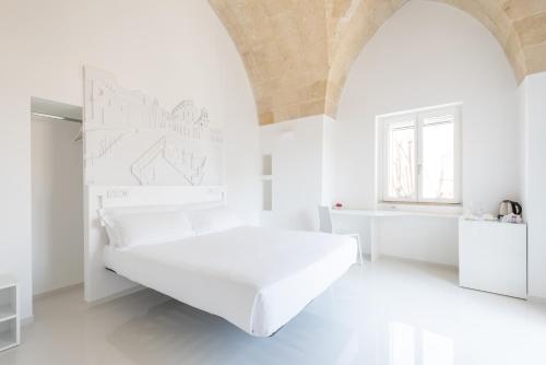 a white bedroom with a white bed in a room at Vittorio Veneto Matera Luxury Rooms in Matera