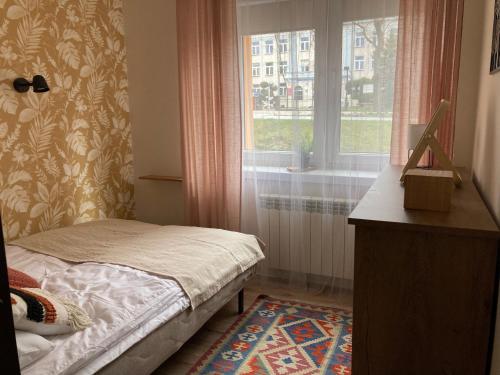 Habitación pequeña con cama y ventana en Apartament Mickiewicza, en Busko-Zdrój