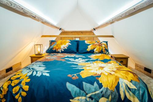 a bedroom with a blue bed with yellow flowers on it at The Granary in Canterbury