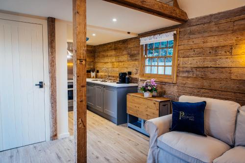 a kitchen with wooden walls and a couch in a room at The Granary in Canterbury