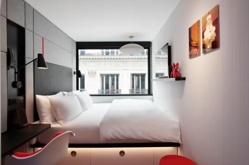 a bedroom with a white bed and a window at citizenM Paris Opera in Paris