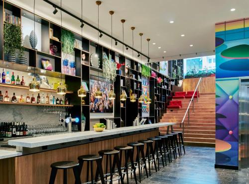 un bar dans un restaurant avec tabourets dans l'établissement citizenM Paris Opera, à Paris