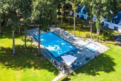 uma vista superior de uma piscina num parque em De Bosdreef - Hengelhoef - duplex met verwarmd openluchtzwembad em Aan de Wolfsberg