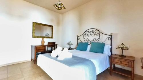 a bedroom with a large white bed with blue pillows at La Maison dAndres, by Comfortable Luxury in La Oliva