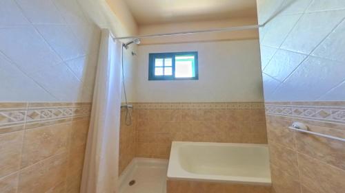 baño con bañera, lavabo y ventana en La Maison dAndres, by Comfortable Luxury, en La Oliva