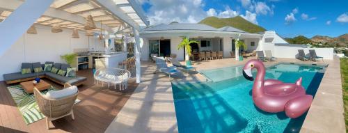 a house with a swimming pool with a pink flamingo in it at SUNSEEKER SXM - Luxury Guest House 4 stars - Amazing Sea View Pinel - Tintamarre in Orient Bay
