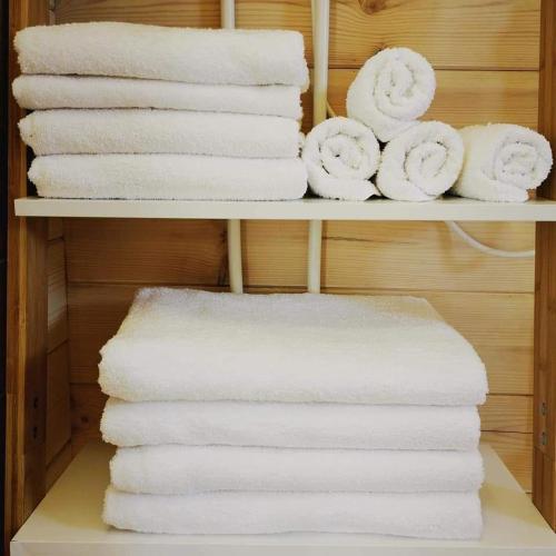a stack of white towels on a shelf at Rio Park domki letniskowe Łukęcin in Łukęcin