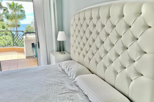 Sitio de CalahondaにあるMI CAPRICHO BEACHFRONT- 9F Apartment with sea views - Costa del Solのベッドルーム(大きな白いベッド1台、バルコニー付)