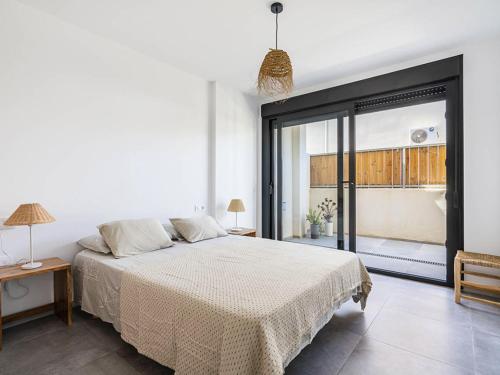 a white bedroom with a bed and a large window at Casa Ailanto in El Pozo de los Frailes