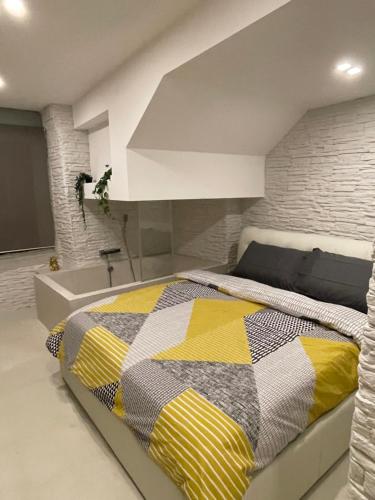 a bedroom with a bed with a yellow and gray quilt at Home Porta Di Castro in Palermo
