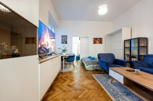 a living room with blue chairs and a table at Mojmirova Apartment Kosice Center in Košice