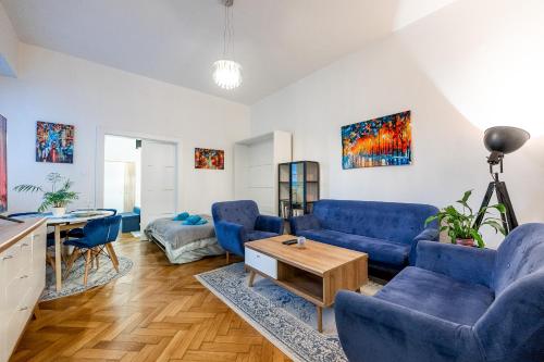 a living room with blue couches and a table at Mojmirova Apartment Kosice Center in Košice