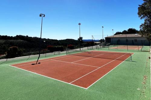 a tennis court with two tennis courts at Charming house village for 6 people in Baudinard