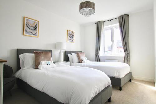 a bedroom with two beds and a window at Cicero Fairfields by Pay As U Stay in Milton Keynes