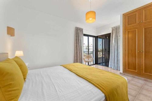 a bedroom with a bed with a yellow blanket on it at Villa RamiMedi 4 in Tías
