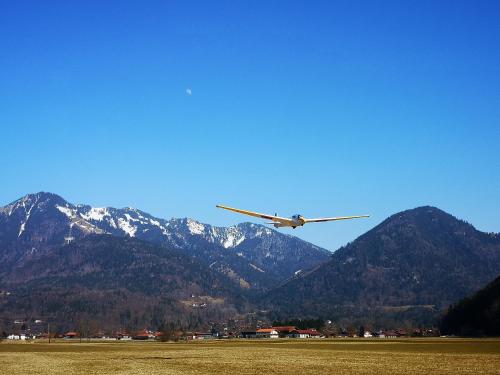 an airplane flying over a field with mountains in the background at Haus Edelweiß in Unterwössen