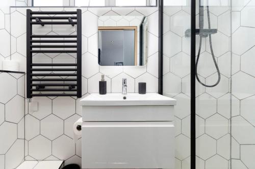 Baño blanco con lavabo y espejo en Charming Ground Floor 1 Bedroom Flat in Twickenham, en Twickenham