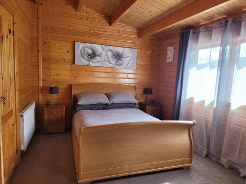 1 dormitorio con 1 cama en una cabaña de madera en Immaculate 2-Bed Lodge Next To Lake, en Preston