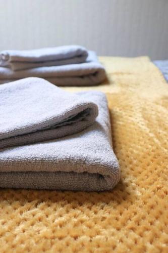 three towels are sitting on top of a bed at Peaceful 2 Bed House FREE WiFi and Parking in Belle Isle